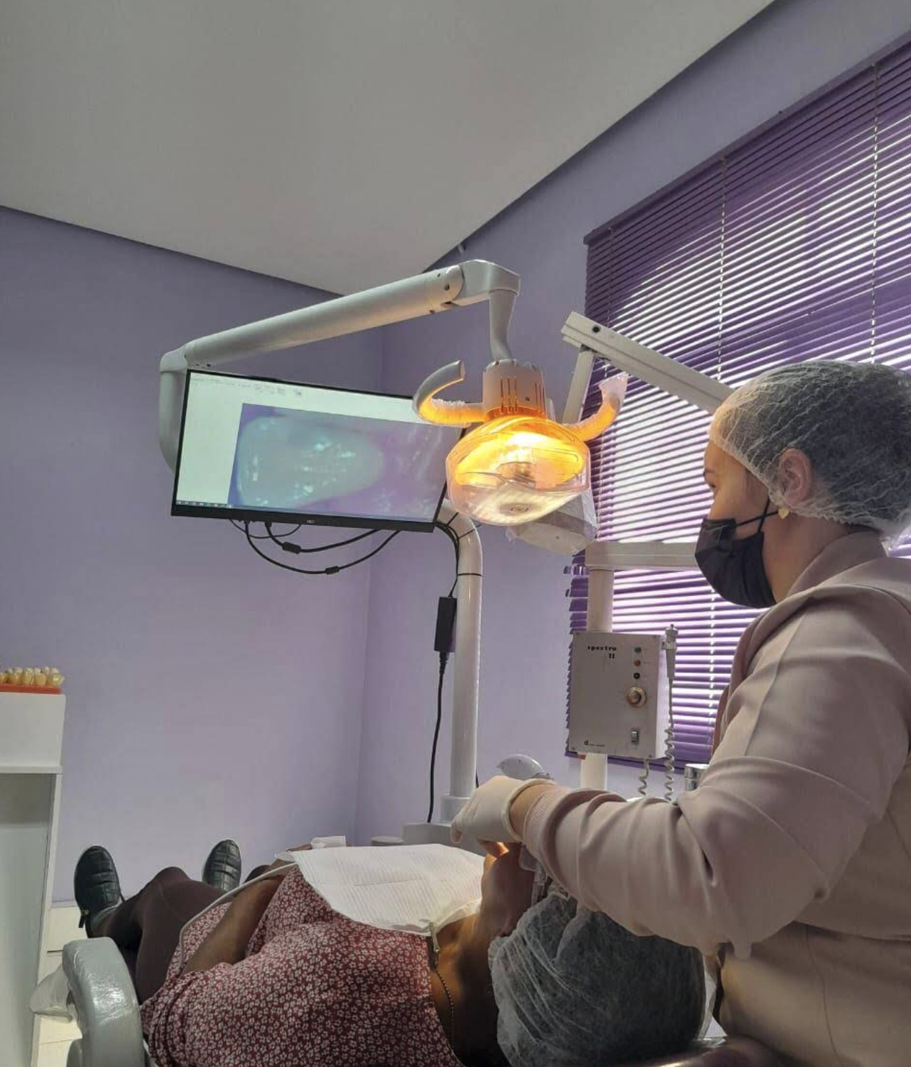 Dentista realizando atendimento na clínica
